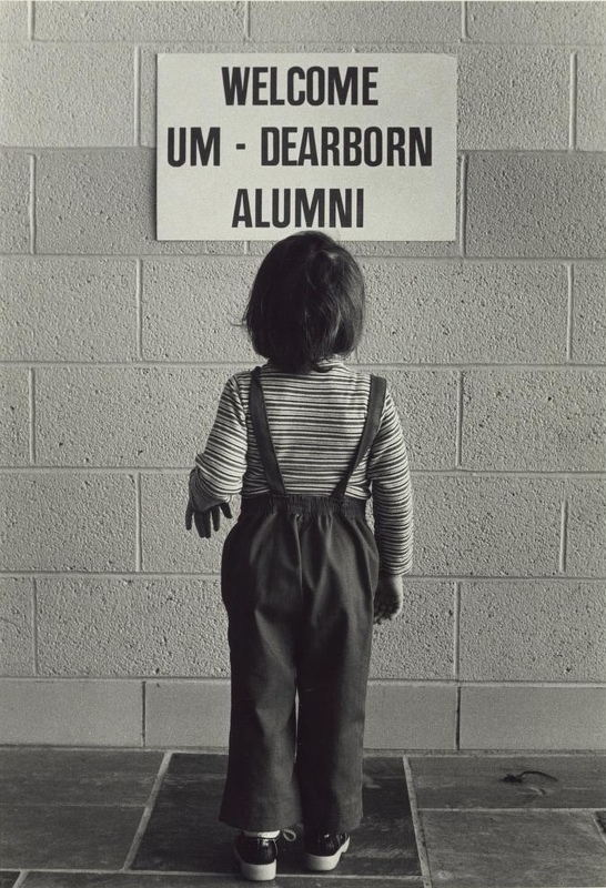  "Welcome UM-Dearborn Alumni" sign being read by child / Philip T. Dattilo