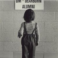  "Welcome UM-Dearborn Alumni" sign being read by child / Philip T. Dattilo